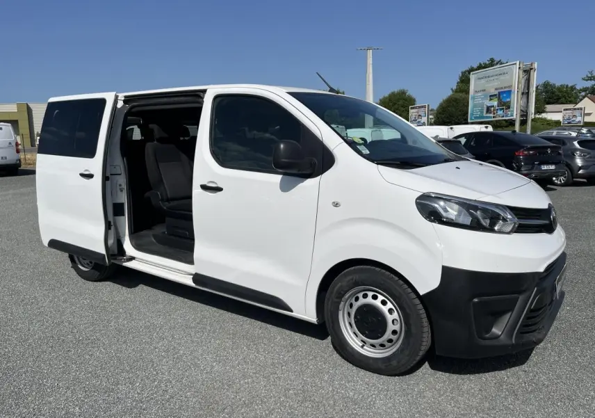 Toyota Proace Fourgon blanc vu en 3/4 avant droit avec porte latérale coulissante ouverte dévoilant l'intérieur.