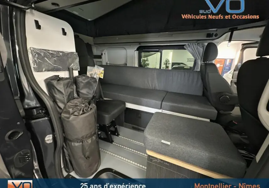 Intérieur du Renault Trafic Fourgon gris 2025, vue latérale droite montrant banquette et équipements modulables.