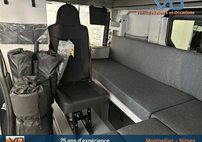 Intérieur du Renault Trafic Fourgon gris 2025 montrant siège avant et banquette latérale en tissu gris.