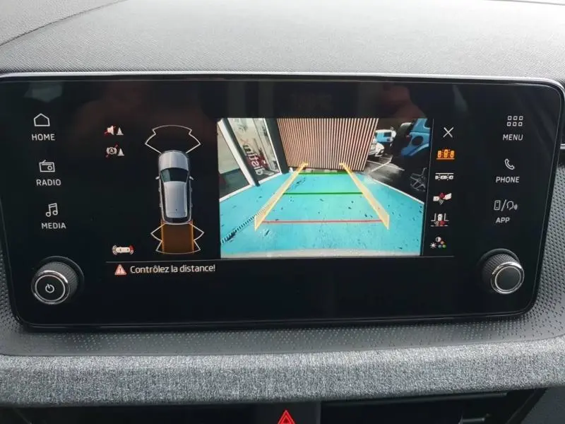 Écran tactile du Skoda Kamiq gris montrant la caméra de recul avec lignes de guidage colorées.