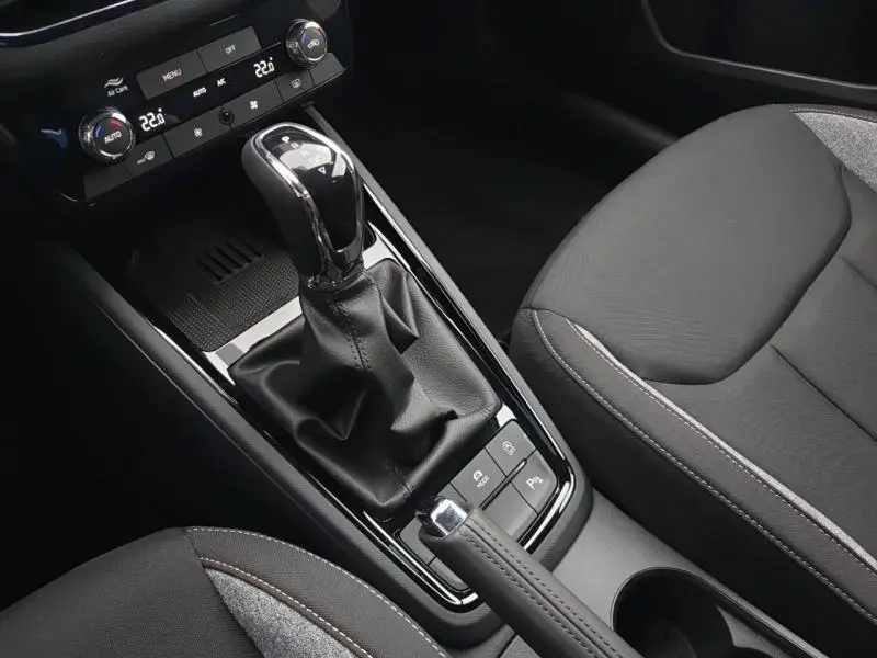 Vue rapprochée de la console centrale intérieure du Skoda Kamiq 2025 avec levier de vitesse automatique et sièges gris.