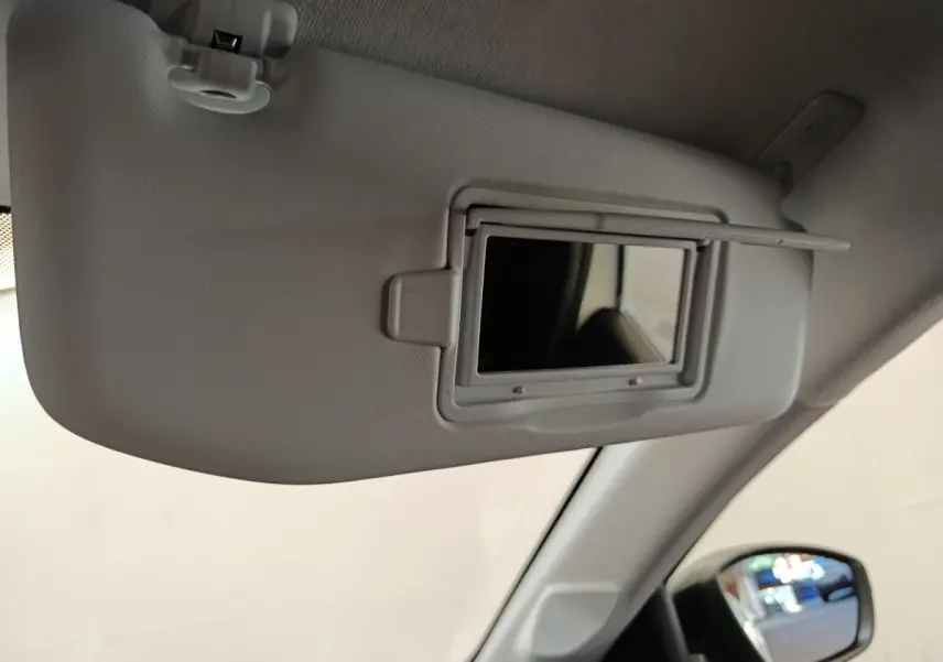 Détail du pare-soleil côté conducteur avec miroir intégré dans l'habitacle clair d'une Peugeot 208 blanche 2023.