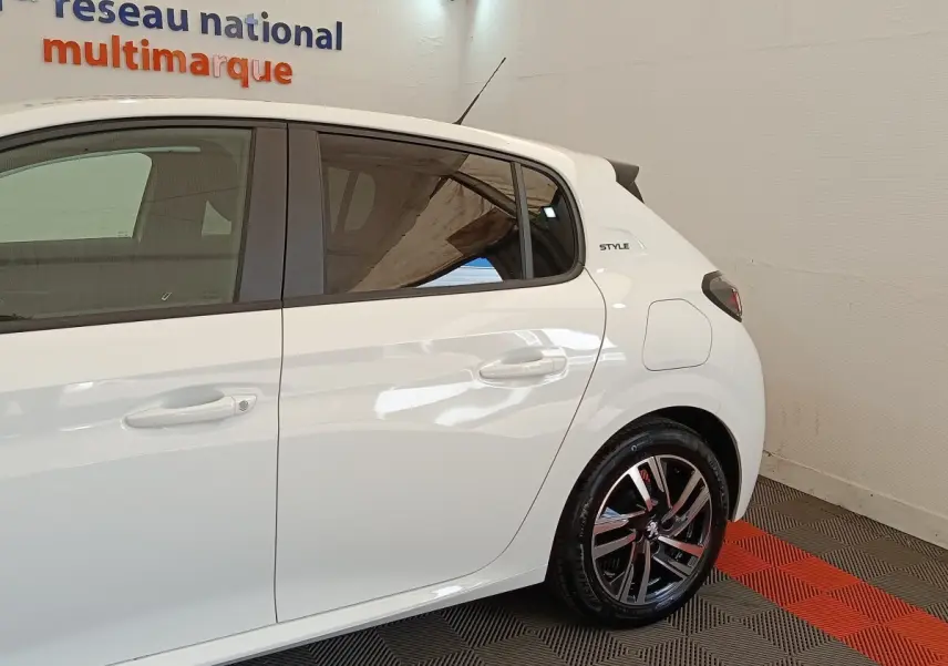 Vue latérale droite d'une Peugeot 208 PureTech 75 S&S Style blanche, avec jantes alliage et badge Style arrière.