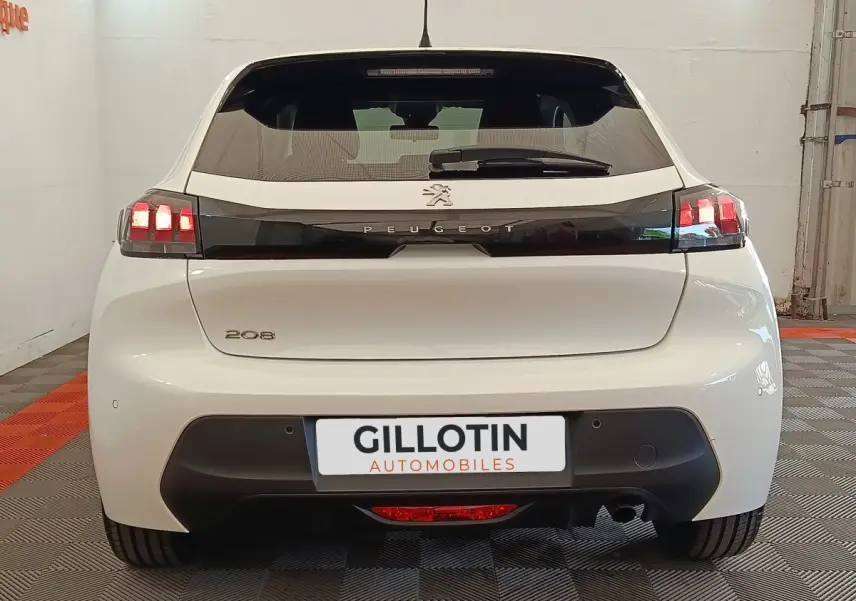 Vue arrière d'une Peugeot 208 blanche 2023 avec feux arrière LED et logo Peugeot noir brillant.