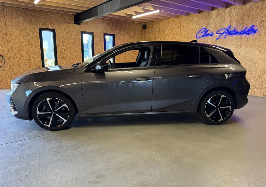 Opel Astra 1.5D 130 BVA8 GS gris vue de profil gauche avec jantes alliage 17'' diamantées dans un garage.