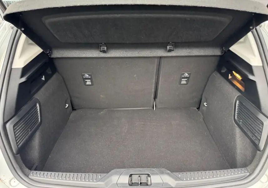 Coffre ouvert de Ford Focus gris 2021, vue intérieure arrière montrant un espace de chargement propre et bien agencé.