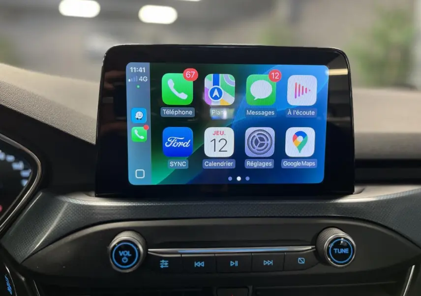 Écran tactile central du Ford Focus 2021 affichant l'interface Apple CarPlay avec commandes audio en dessous.