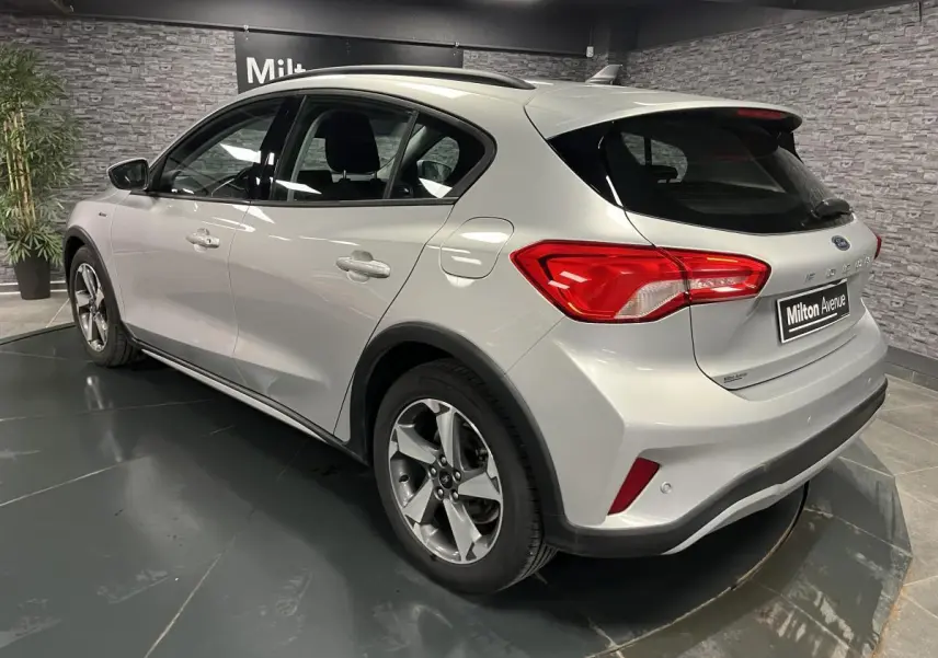 Vue 3/4 arrière droite d'une Ford Focus 1.0 EcoBoost gris lunaire avec jantes alliage et feux arrière LED.