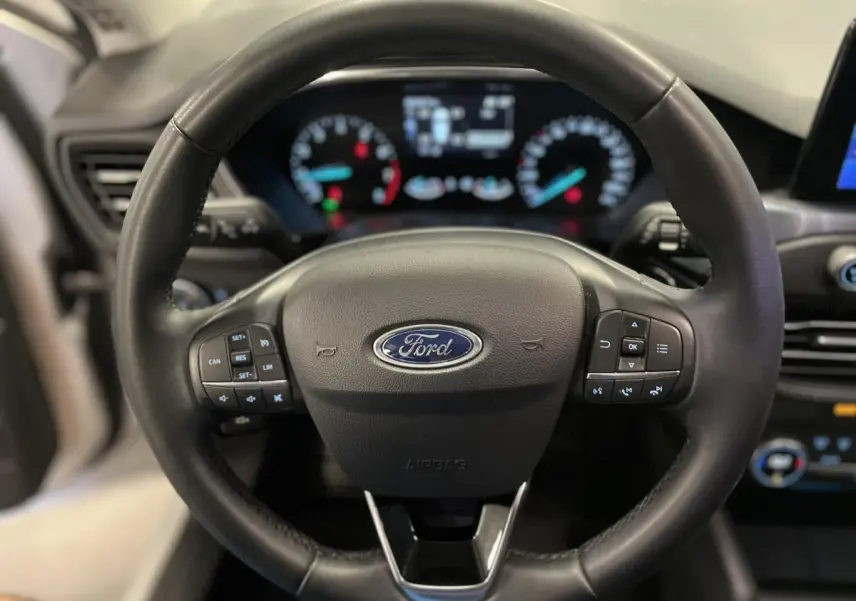 Volant cuir noir Ford Focus 2021 avec commandes intégrées, tableau de bord numérique flou en arrière-plan