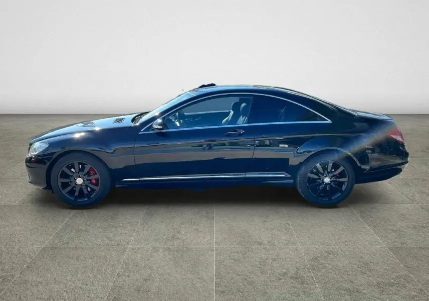 Profil côté gauche d'une Mercedes Classe CL 500 4-Matic noire avec jantes alliage noires et étriers rouges.