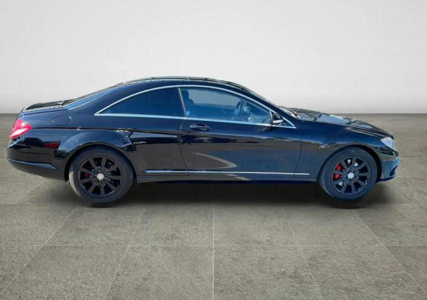 Profil côté gauche d'une Mercedes Classe CL 500 4-Matic noire avec jantes alliage noires et étriers rouges.