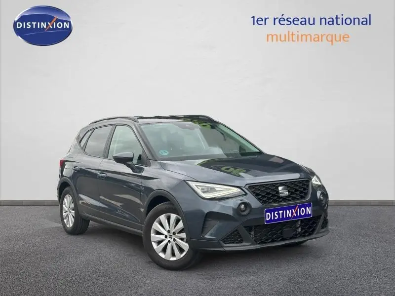 Vue 3/4 avant d'un SEAT Arona 2025 gris Magnétique Métal avec toit noir et jantes argentées, sur fond neutre.