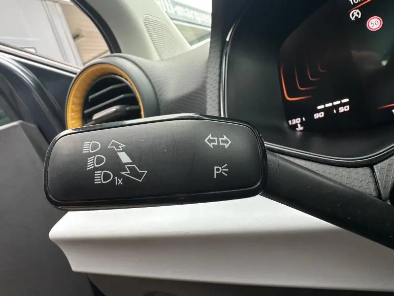 Gros plan sur le commodo gauche du volant du SEAT Arona 2025, avec détails des commandes d’éclairage et clignotants.