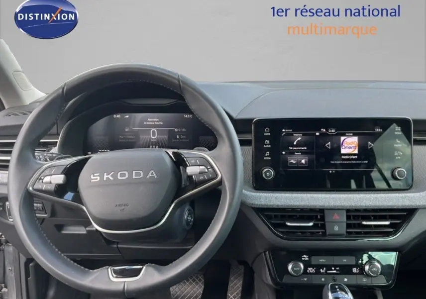 Vue intérieure centrée sur le volant SKODA et l'écran tactile du tableau de bord d'une SCALA gris graphite.