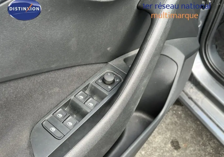 Détail de la porte côté conducteur d’une Skoda Scala gris graphite, montrant les commandes des vitres et rétroviseurs.