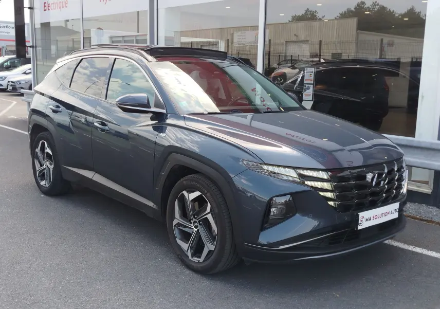 Vue 3/4 avant d’un Hyundai Tucson 2021 Teal Blue Métal avec calandre distinctive et jantes alliage modernes.