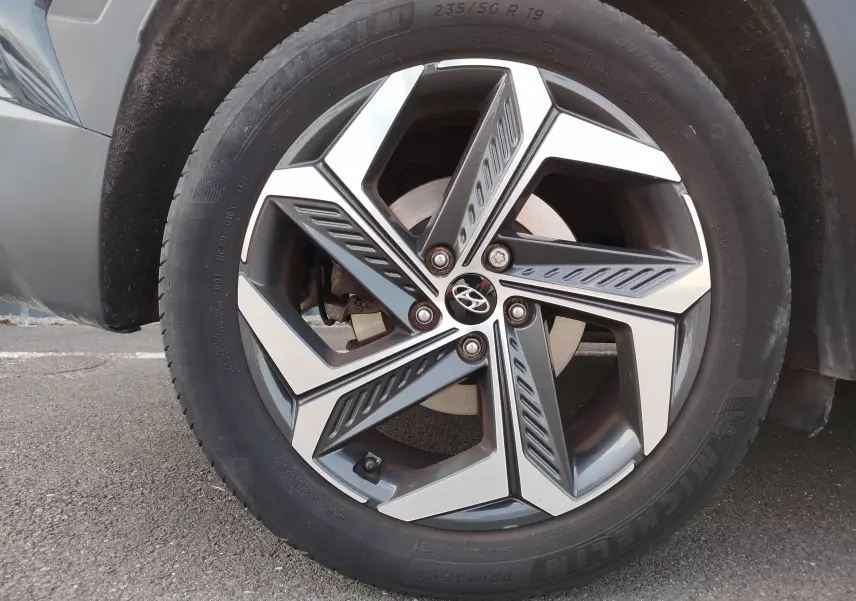 Gros plan sur la jante alliage au design moderne du Hyundai Tucson 1.6 CRDI Teal Blue Métal, pneu Michelin visible.
