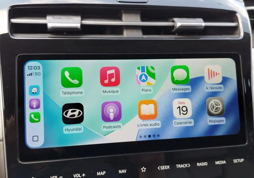 Gros plan sur l’écran tactile intérieur du Hyundai Tucson 2021, affichant Apple CarPlay avec interface colorée.
