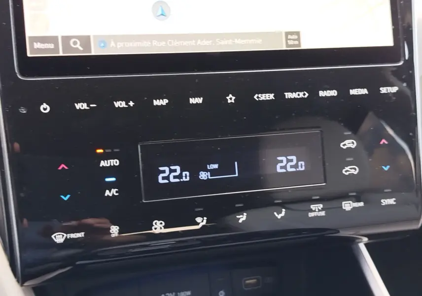 Détail de la console centrale du Hyundai Tucson 2021 en Teal Blue, affichant la climatisation automatique à 22°C.