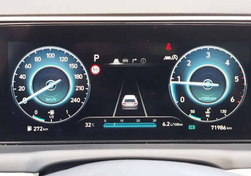 Tableau de bord numérique du Hyundai Tucson 2021 affichant vitesse, régime moteur, autonomie et indicateurs d'aide à la conduite.