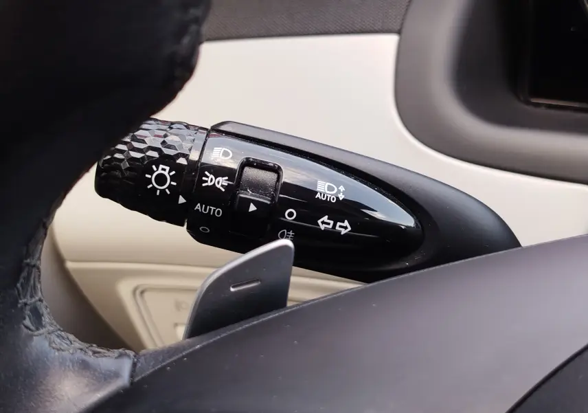 Gros plan sur la manette de commande d’éclairage à gauche du volant dans l’habitacle beige du Hyundai Tucson 2021.