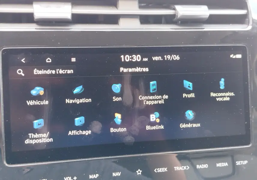 Écran tactile central du Hyundai Tucson 2021 affichant le menu des paramètres avec icônes bleues sur fond noir.