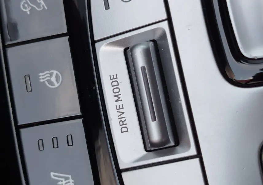 Gros plan sur les commandes argentées et noires du mode de conduite et des fonctions chauffantes dans le Hyundai Tucson 2021.