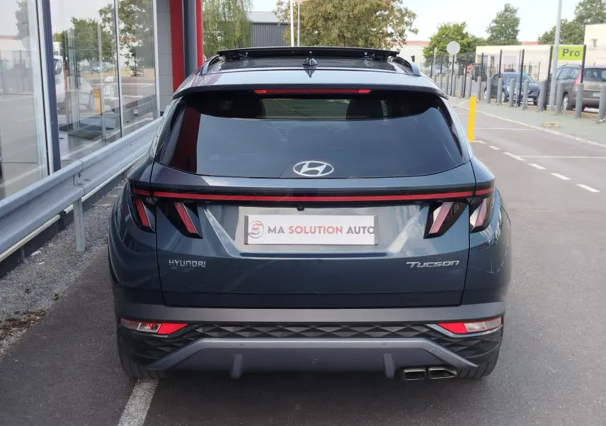 Vue arrière d'un Hyundai Tucson 2021 Teal Blue Métal avec feux arrière LED et double sortie d'échappement carrée.
