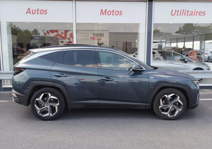 Vue de profil côté gauche d’un Hyundai Tucson 2021 Teal Blue Métal, soulignant ses jantes alliage et lignes anguleuses.