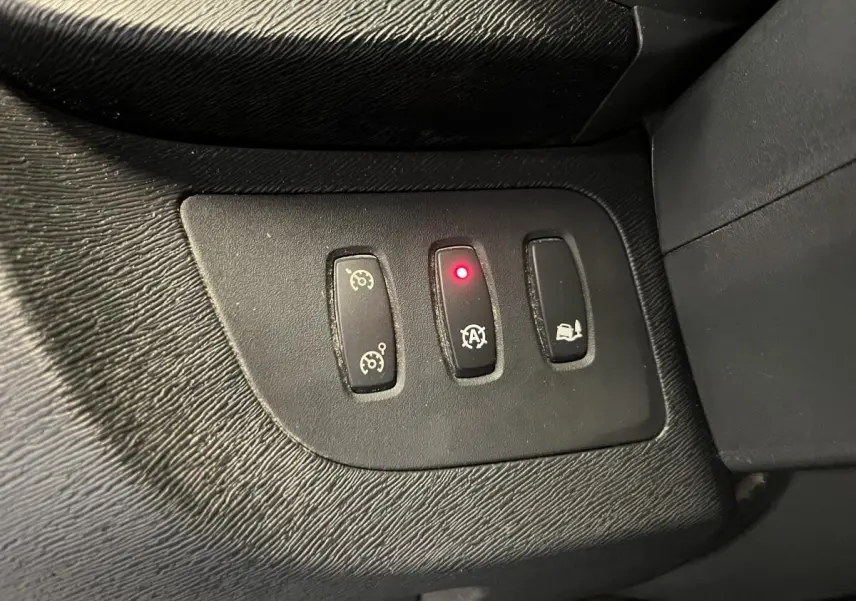 Gros plan sur les commandes du régulateur de vitesse et de l'arrêt automatique du moteur du Renault Kangoo Express gris foncé.