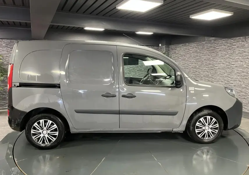 Profil droit d'un Renault Kangoo Express gris foncé avec portes latérales coulissantes tôlées et enjoliveurs noirs.