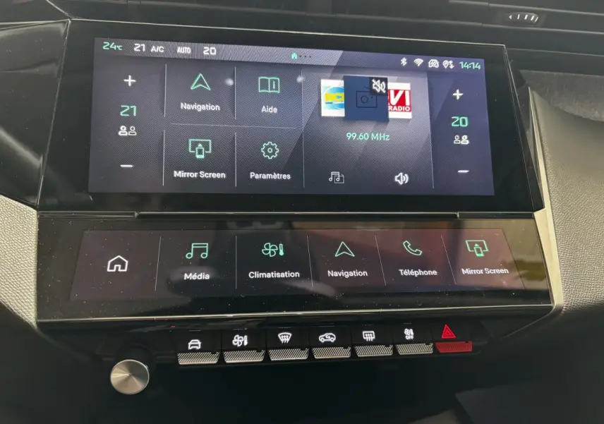 Gros plan sur l'écran tactile central et la console de la Peugeot 308 PureTech 130 S&S Allure gris clair, affichage multimédia et climatisation.