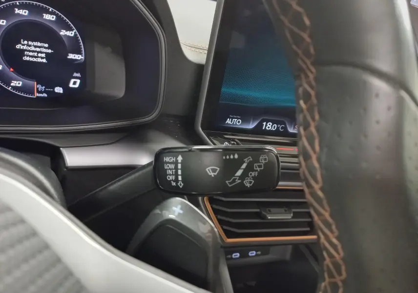 Gros plan sur la commande d’essuie-glace à gauche du volant du CUPRA Formentor gris magnétique, avec tableau de bord numérique.