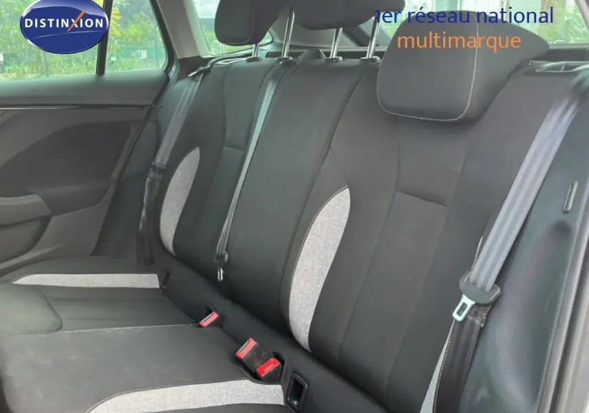 Vue latérale gauche de l’intérieur arrière de la Skoda Scala 2025, sièges tissu noir et gris clair avec ceintures visibles.