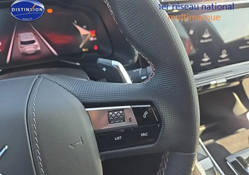 Gros plan sur le volant perforé du DS7 Cristal Pearl 2025 avec commandes intégrées et tableau de bord numérique visible.