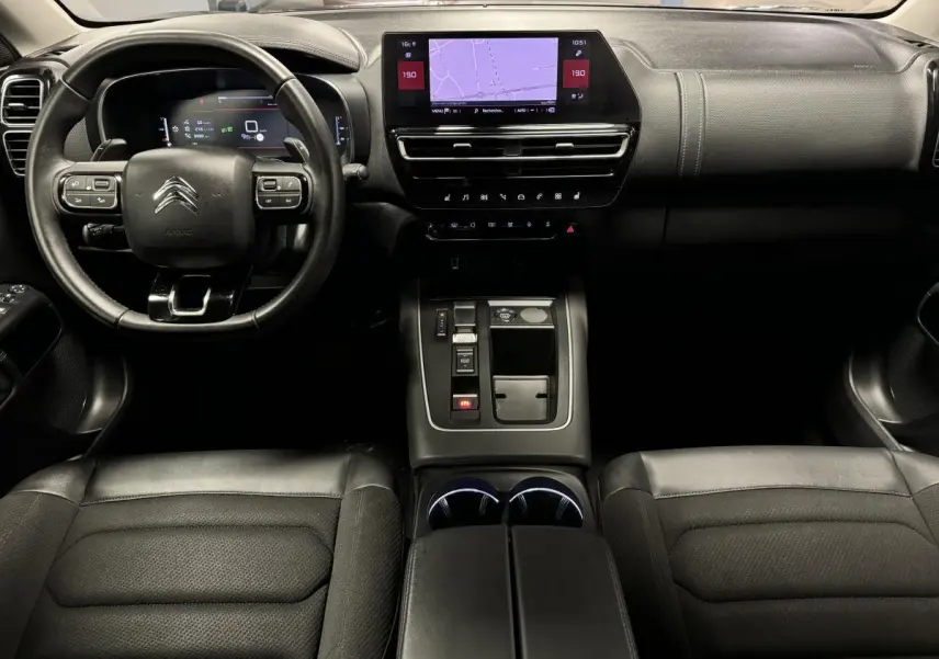 Vue intérieure avant du Citroën C5 Aircross noir avec tableau de bord numérique et console centrale moderne.