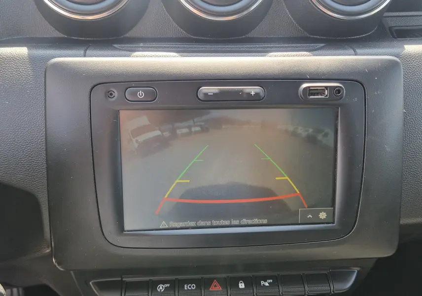 Écran central du tableau de bord du Dacia Duster 2021 montrant la caméra de recul avec lignes de guidage colorées.