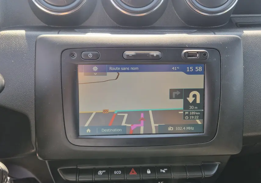 Écran central du GPS du Dacia Duster 2021 affichant un itinéraire avec indication de virage à 30 m.