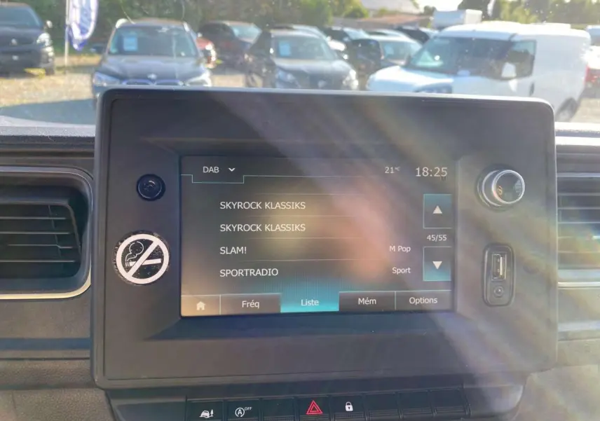 Écran tactile central du tableau de bord de l'Opel Movano Fourgon blanc, affichant les stations radio DAB.