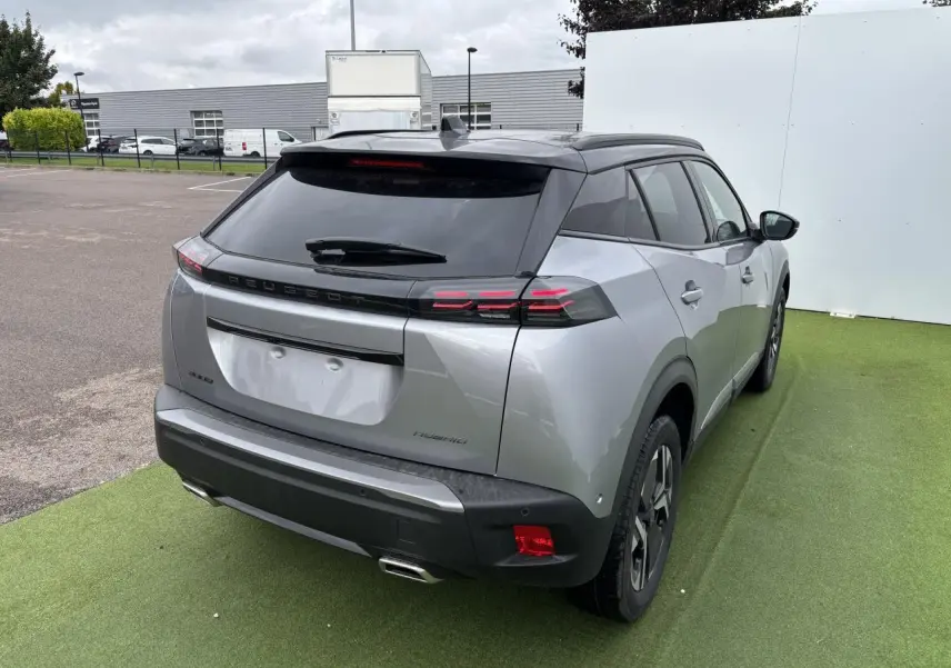Vue 3/4 arrière droite d'un Peugeot 2008 gris Artense avec toit noir, feux arrière LED à 3 griffes et double sortie d'échappement chromée.