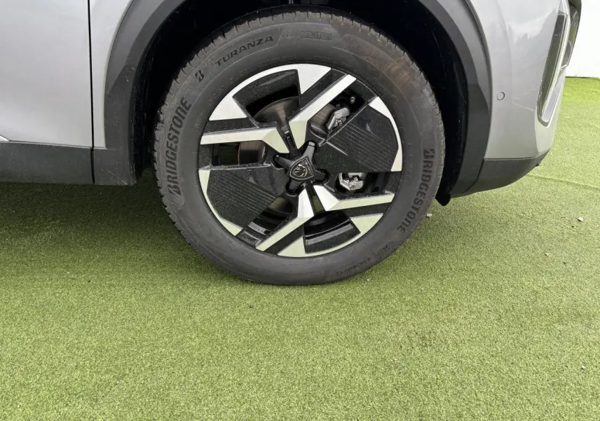 Gros plan sur la roue avant gauche du Peugeot 2008 gris Artense avec jante alliage 17'' bi-ton noir et argent.