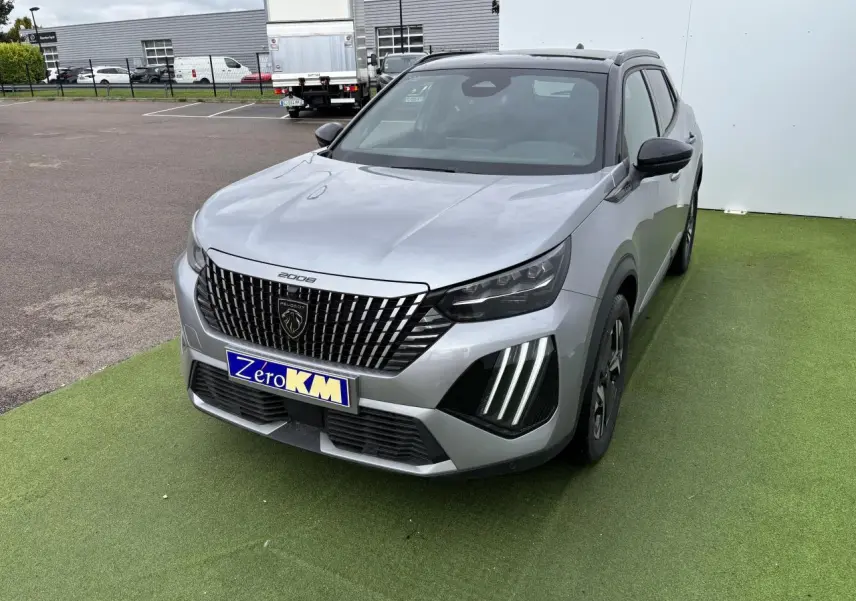 Peugeot 2008 II gris Artense toit noir en 3/4 avant droit, calandre noire verticale et feux LED griffés visibles