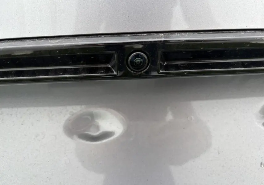 Gros plan sur la caméra 360° arrière intégrée à la malle du Peugeot 2008 gris Artense avec toit noir.