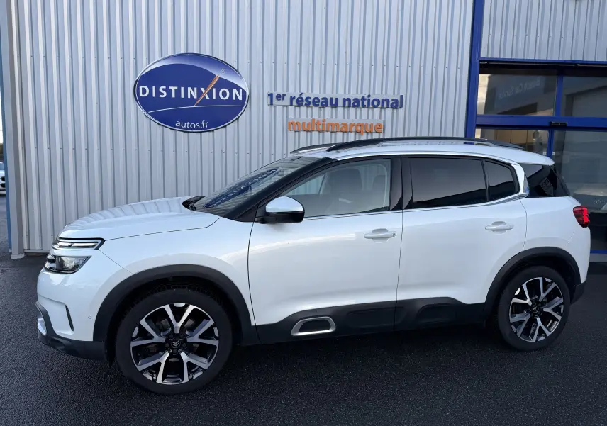 Profil droit d'un Citroën C5 Aircross blanc nacré 2021 avec jantes biton et protections noires basses.