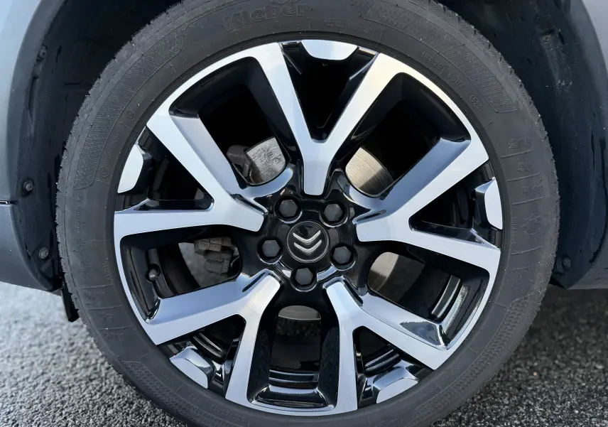 Gros plan sur la jante alliage bicolore noire et argentée du Citroën C5 Aircross blanc nacré, version 2021.