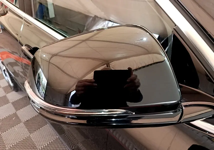 Rétroviseur droit noir brillant de BMW X2 sDrive18i Lounge 2023 avec clignotant intégré, vue rapprochée.