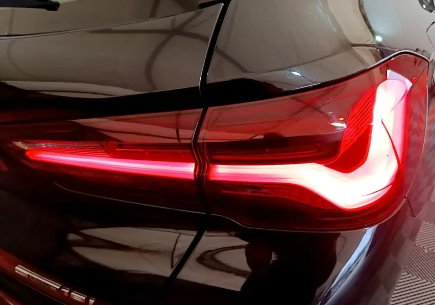 Gros plan sur le feu arrière droit allumé d’un BMW X2 sDrive18i Lounge noir 2023.