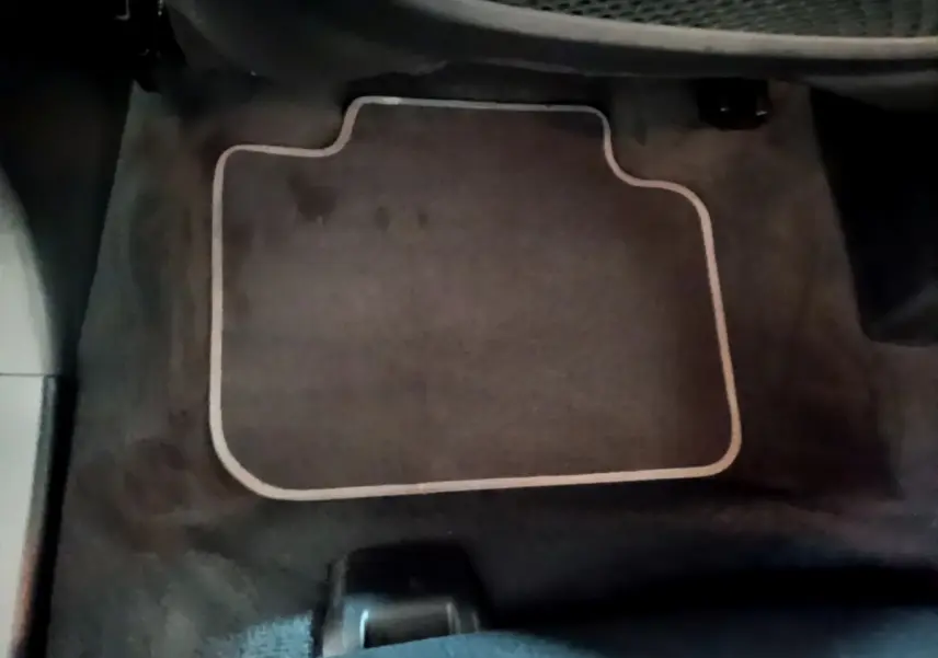 Vue intérieure du tapis de sol noir côté passager avant d'une BMW X2 sDrive18i Lounge 2023.