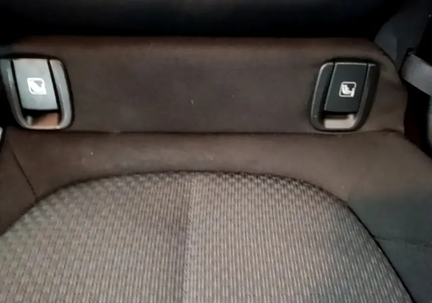 Gros plan sur la banquette arrière noire du BMW X2 sDrive18i Lounge 2023 avec commandes de rabattement des sièges visibles.