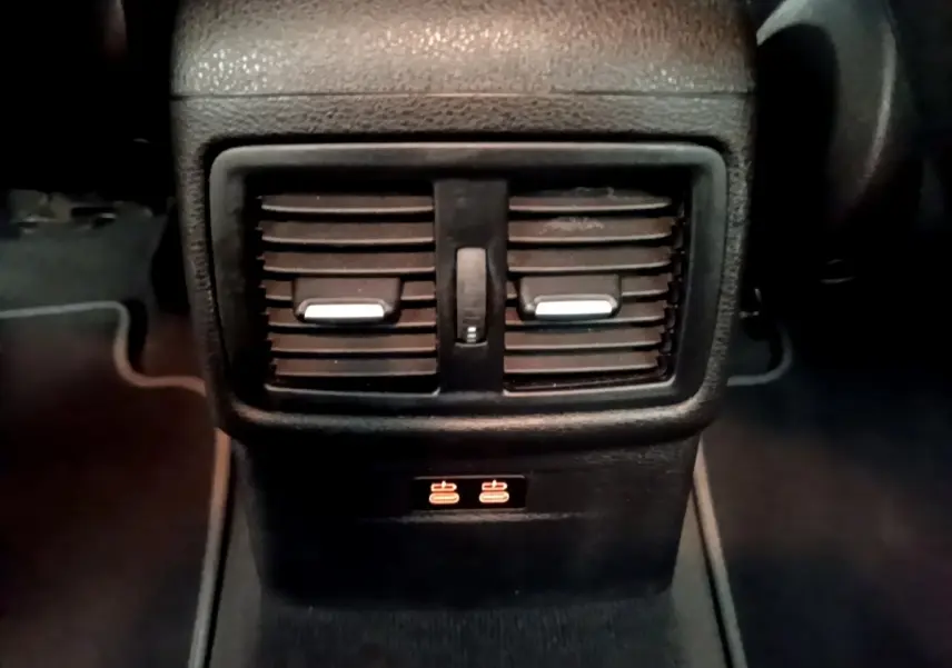 Détail des aérateurs arrière noirs avec commandes de ventilation et ports USB illuminés dans BMW X2 sDrive18i Lounge 2023.